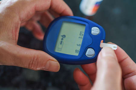 Medicine, Diabetes, Glycemia, Health care and people concept - close up of female using lancelet on...