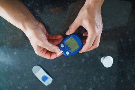 Medicine, Diabetes, Glycemia, Health care and people concept - close up of female using lancelet on...