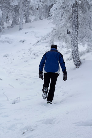 man hiking for a snowy mountain. Feeling of loneliness and calm. Concept of improvement and challenge.の写真素材