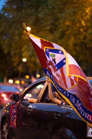Madrid, Spain. 22 th May 2021. Atletico de Madrid celebrating the 2021 league title in the street. A car waves a team banner from the window.のeditorial素材