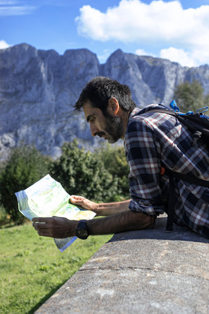 Hiking man looking at map in mountains. Hiking concept.の写真素材