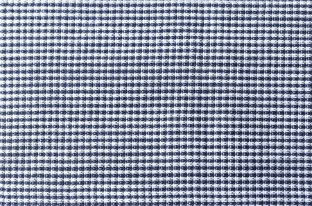 A checkered print fabric with a black and white color combination. The pattern is made up of squares...