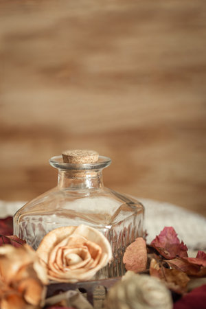 Classic-style Christmas still life of glass bottle and colorful flowers. Brown background. Vertical.の写真素材