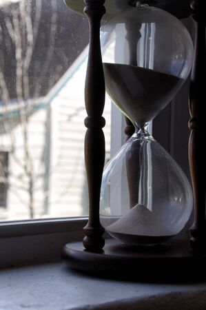 Large hour glass in a window to the right of frameの写真素材