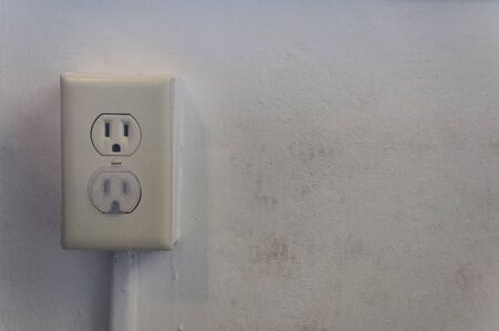 Two electric outlets, the bottom one covered with a child safety plug, and the top one is not, copy...
