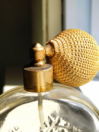 Close up view of an old vintage glass perfume bottle, with atomizer diffuserの写真素材