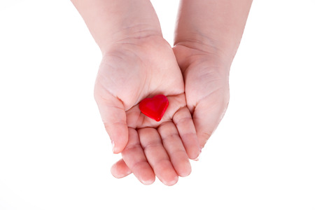 hands hold a red heart on white backgroundの写真素材