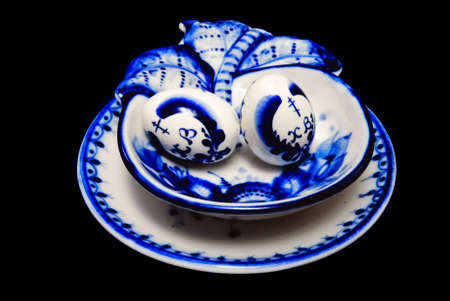 Gzhel painted objects: easter eggs in plate isolated over black backgroundの写真素材
