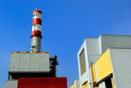 Constructions of refuse incinerator power station over blue skyの写真素材