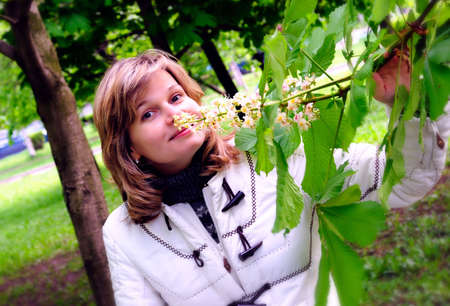 Pretty girl and  inflorescence of blossomed chestnut-treeの写真素材