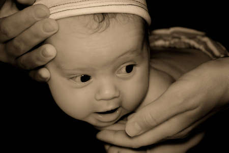 Toned portrait of the kid training to hold a head by means of mum's handsの写真素材