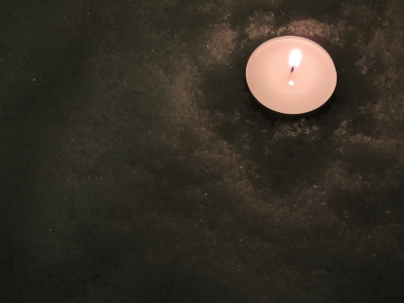           one flame candle in snowの写真素材