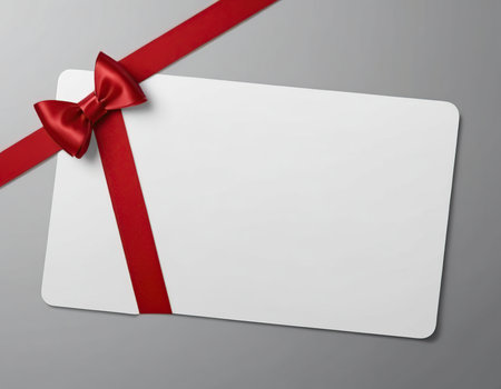 close up of a note card with red ribbon bow on gray backgroundの素材