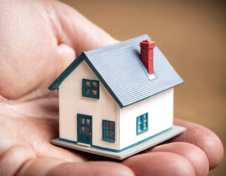 Miniature house in human hand, real estate and property concept.の素材