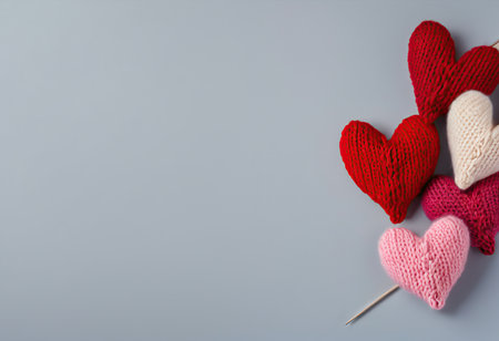 Knitted hearts and needles on gray background. Valentine's day conceptの素材