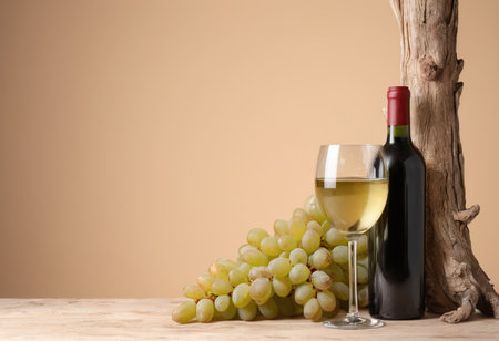 Bottle and glass of wine with bunch of grapes on wooden tableの素材