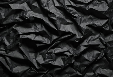 Black creased crumpled paper background grunge texture backdrop.の素材
