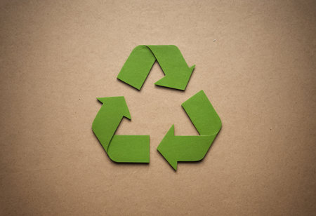 Recycle symbol made of origami paper on a brown background.の素材