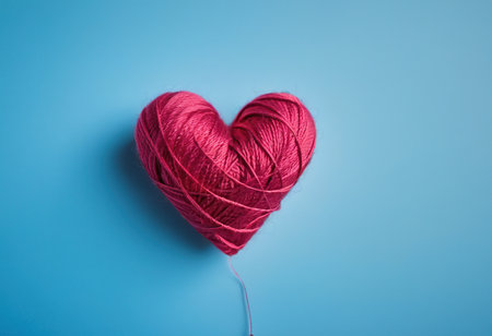 heart shape made of pink thread on blue background, valentines day conceptの素材