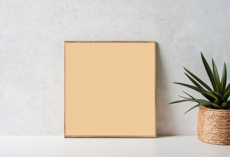 Mockup of blank golden frame on white table and concrete wall backgroundの素材