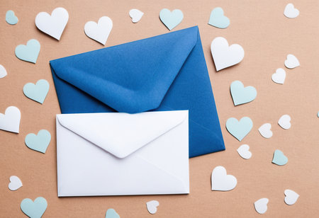 Envelope and paper hearts on a brown background. Valentine's day conceptの素材