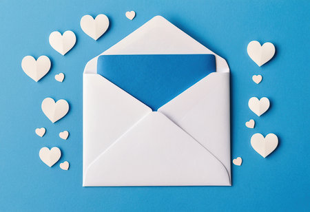 Envelope with paper hearts on a blue background. Valentine's Dayの素材