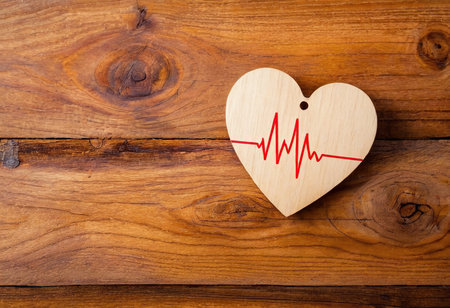 Wooden heart on a wooden background with a cardiogram.の素材