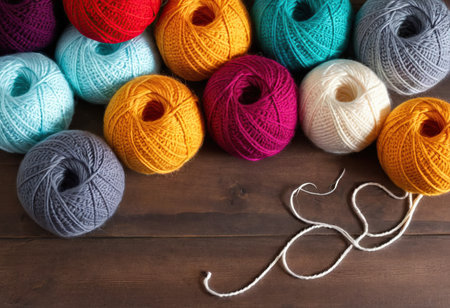 colorful wool balls for knitting on a wooden background, top viewの素材