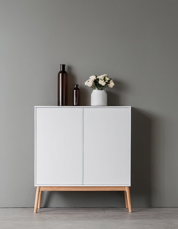 White chest of drawers with vase of flowers on gray wallの素材