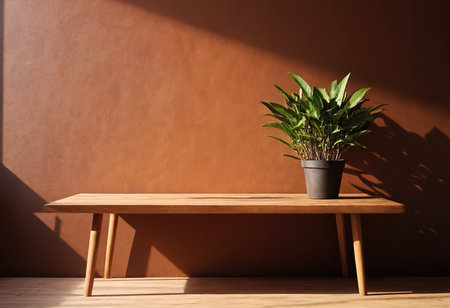 Wooden table and plant in pot on brown wall background with sunlightの素材