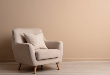 Comfortable armchair with pillows on floor near beige wallの素材