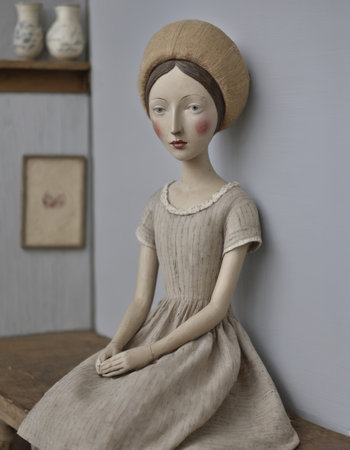 Ceramic doll in a beige dress and a brown hatの素材