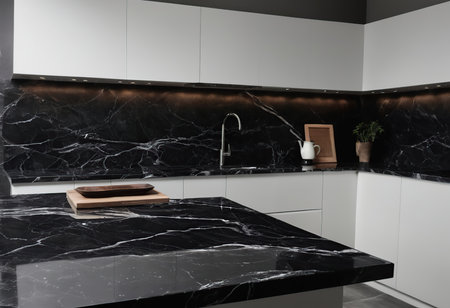 interior of modern kitchen with black marble countertop and built in sinkの素材