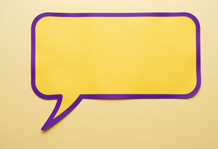Purple paper speech bubble on yellow background with copy space for textの素材