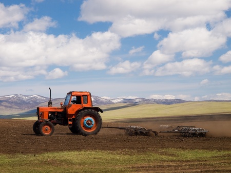 Vintage russian tractor working on mongolian fieldの写真素材