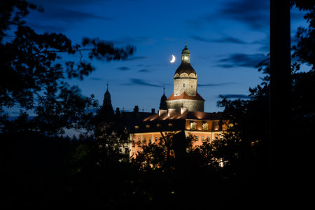 Historic polish castle Ksiaz with the moon and trees in the nightのeditorial素材