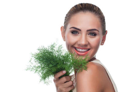 Close-up portrait of happy young woman with  bundle herbs  dill  in hands on white background   Concept vegetarian dieting - healthy foodの写真素材