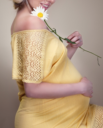 Beautiful Pregnant woman holding spring flowersの写真素材