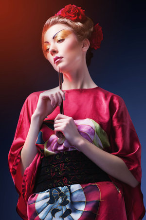 Fashion asian woman wearing traditional japanese red kimono, studio shot  Geishaの写真素材