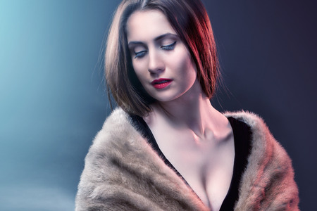 Fashion woman wearing in winter fur coat  on blur backgroundの写真素材
