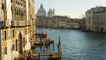 Canals reflect sunlight as boats glide through the water, showcasing Venice's stunning architecture and vibrant atmosphere on a sunny afternoon.の写真素材