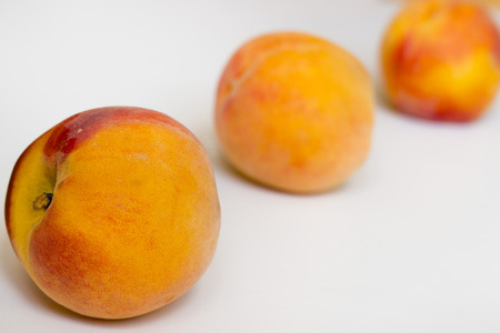 Three peaches on a white background の写真素材
