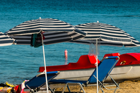 Parasols sunbeds and a catamaran on the beach.の写真素材