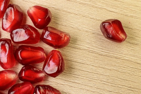 Pomegranate seeds. Macro on a Wood background.の写真素材