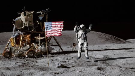 Astronaut jumping on the moon and saluting the American flag.の写真素材
