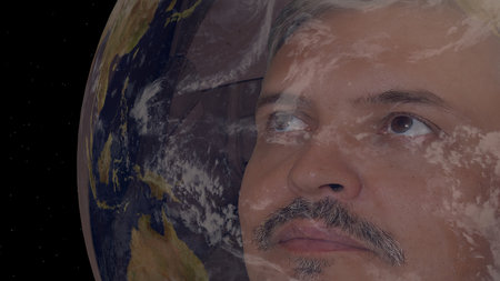 Portrait of man astronaut in outer space wearing helmet looking at earth globe. Sci-fi expedition,...