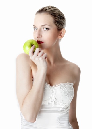  A young, beautiful woman holding a green appleの写真素材