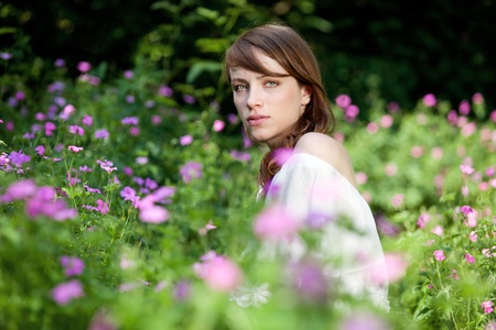 Young lady is surrounded by summer flowers の写真素材