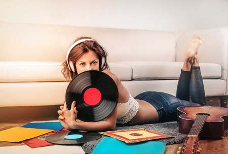 Woman is listening to music on the carpetの写真素材