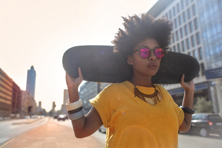 Cool girl is walking with her skateboardの写真素材